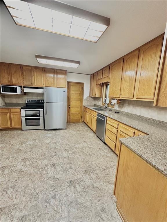 kitchen featuring sink, light stone counters, and stainless steel appliances