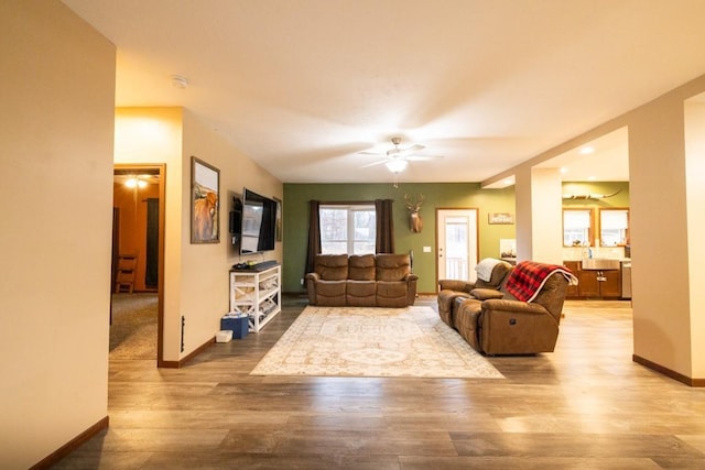 living room featuring ceiling fan, hardwood / wood-style floors, and sink