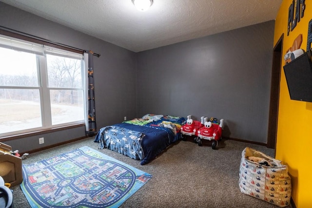 bedroom with multiple windows, carpet, and a textured ceiling