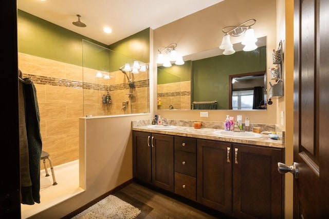 bathroom featuring hardwood / wood-style floors, vanity, and tiled shower