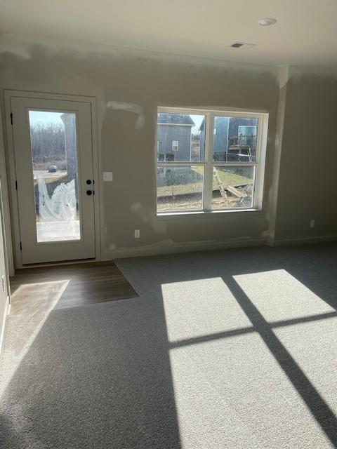 interior space with visible vents, baseboards, and carpet