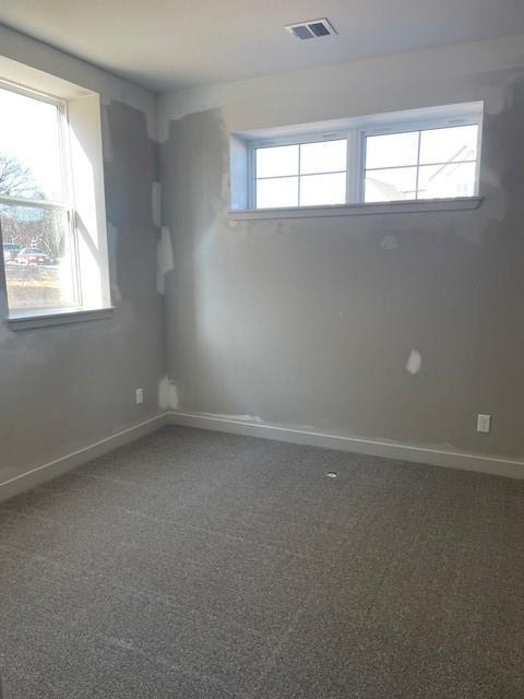 carpeted empty room with baseboards and visible vents