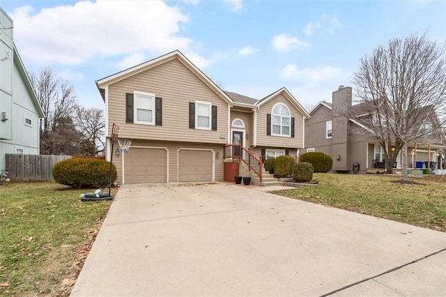 split foyer home with a garage and a front lawn