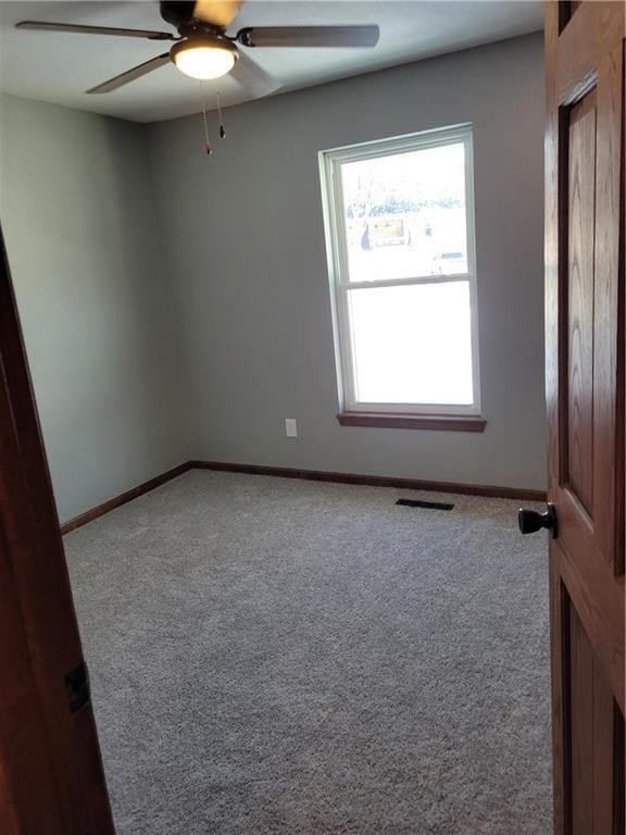 carpeted empty room featuring ceiling fan