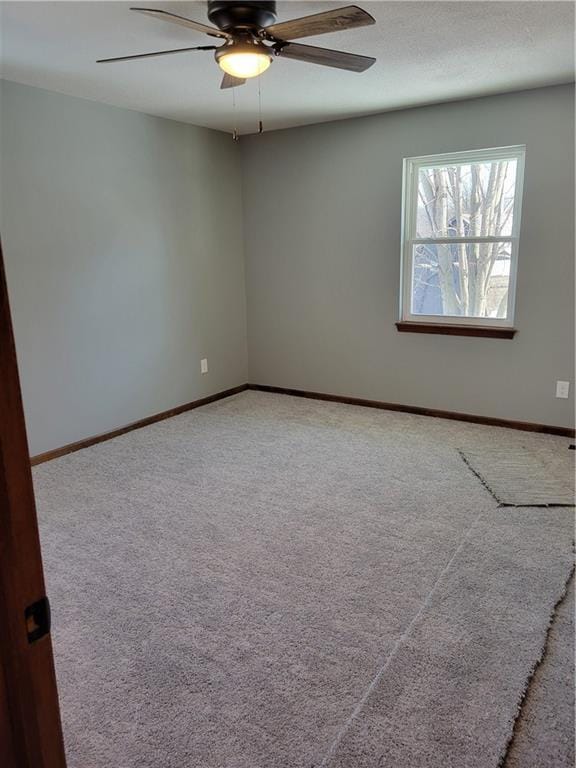 unfurnished room featuring ceiling fan and carpet