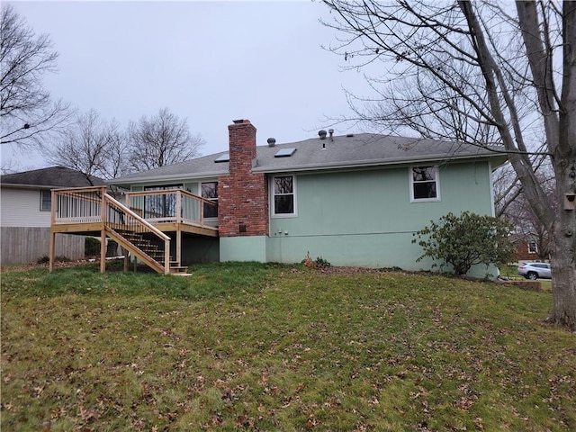 back of property featuring a yard and a wooden deck