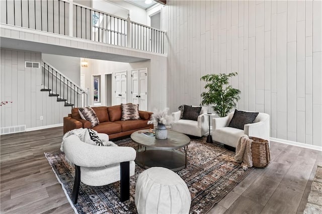 living room with wood-type flooring and a high ceiling