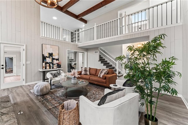 living room featuring hardwood / wood-style floors, beam ceiling, and a high ceiling