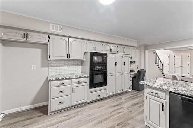 kitchen with crown molding, light stone countertops, decorative backsplash, and black appliances