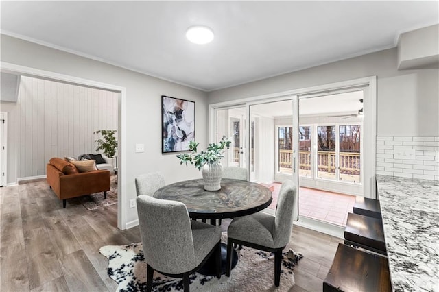 dining space with ornamental molding and wood-type flooring