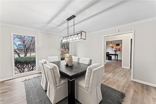 dining area featuring ornamental molding and light hardwood / wood-style floors