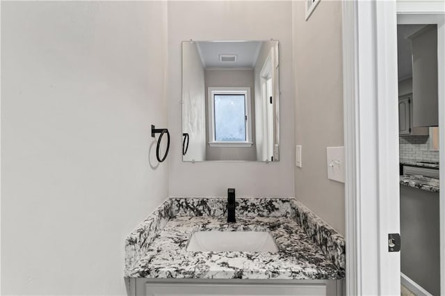 bathroom with vanity and decorative backsplash