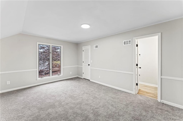 unfurnished room featuring vaulted ceiling and carpet