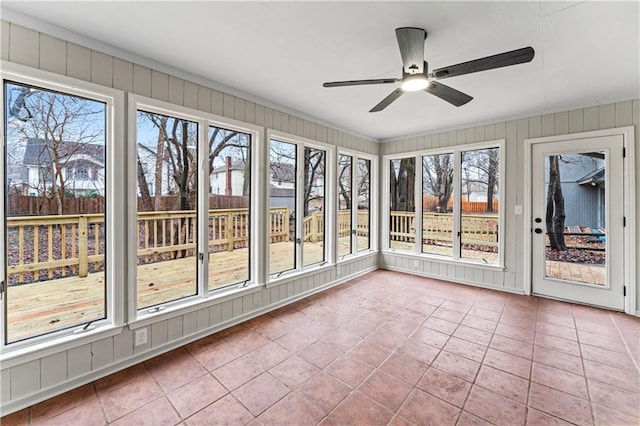 unfurnished sunroom with ceiling fan