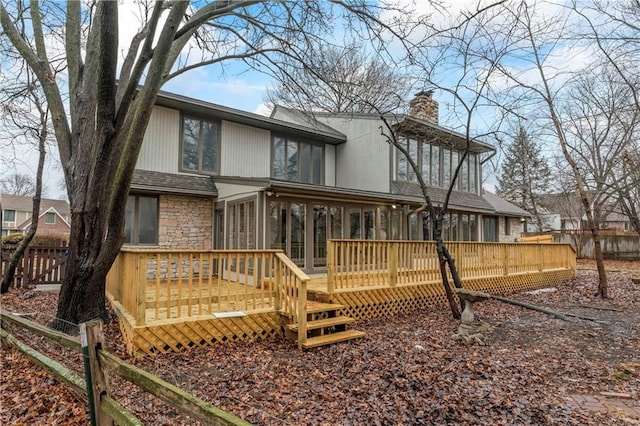 back of property with a wooden deck and a sunroom