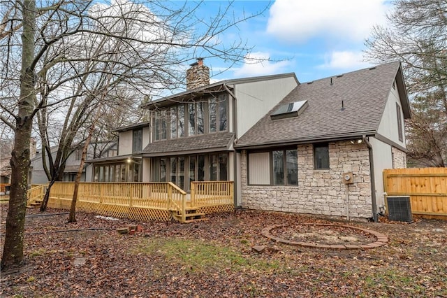 back of property with cooling unit, a sunroom, and a deck