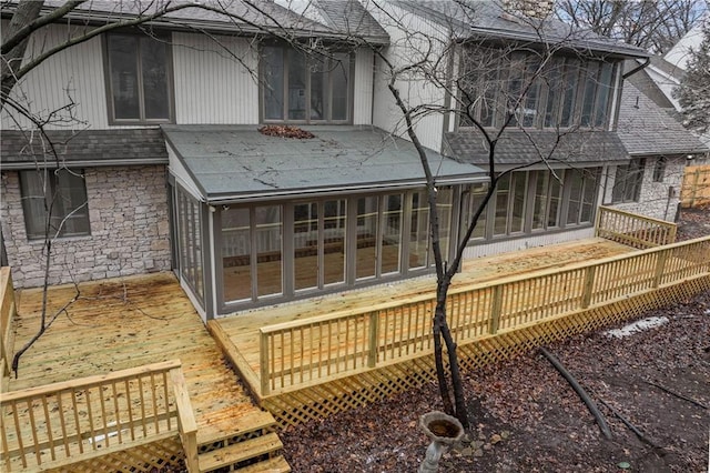 back of property with a deck and a sunroom