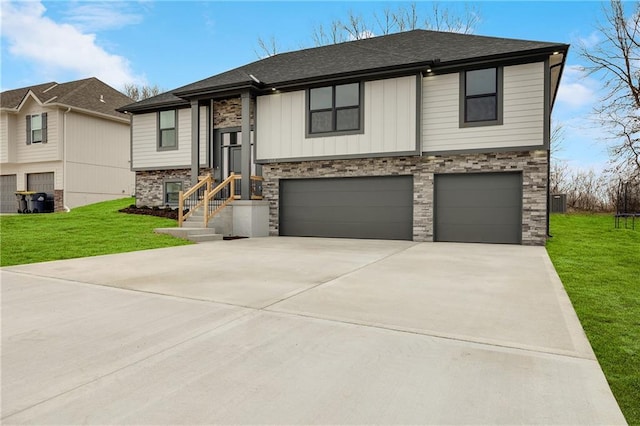 split foyer home with driveway, roof with shingles, a front yard, and an attached garage