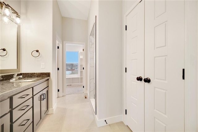 bathroom with vanity, tile patterned flooring, and baseboards
