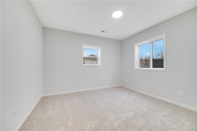 carpeted empty room with baseboards and visible vents