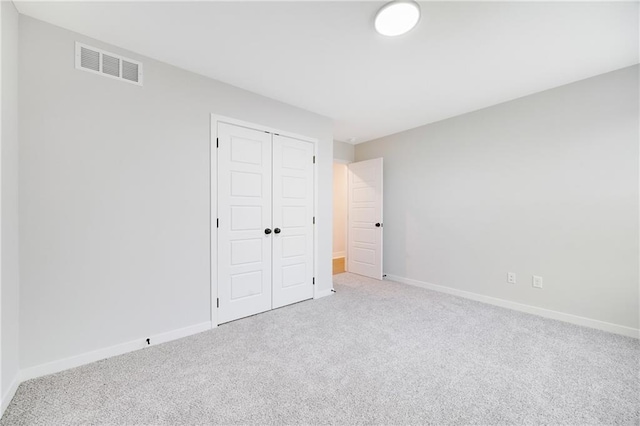 unfurnished bedroom featuring carpet flooring, a closet, visible vents, and baseboards
