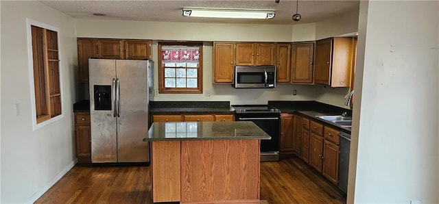 kitchen featuring dark hardwood / wood-style flooring, sink, a kitchen island, and appliances with stainless steel finishes