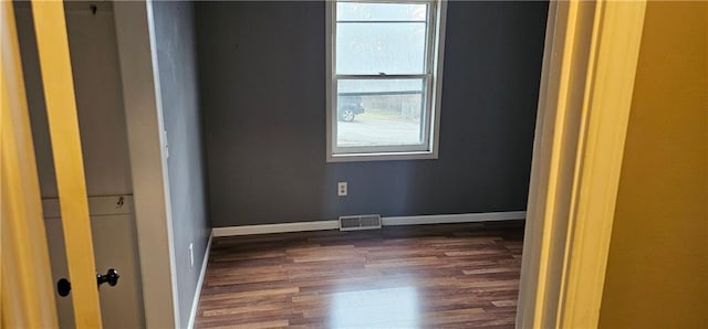 empty room with dark hardwood / wood-style flooring