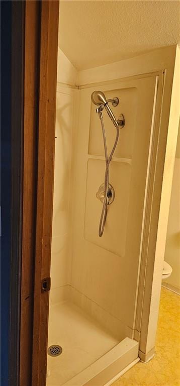 bathroom featuring a textured ceiling and a shower