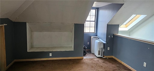 additional living space with lofted ceiling with skylight and carpet flooring