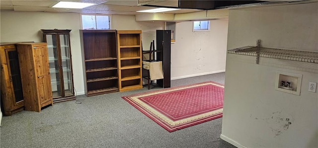 basement with dark carpet and a paneled ceiling