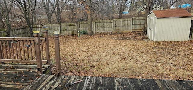 view of yard featuring a wooden deck and a storage unit