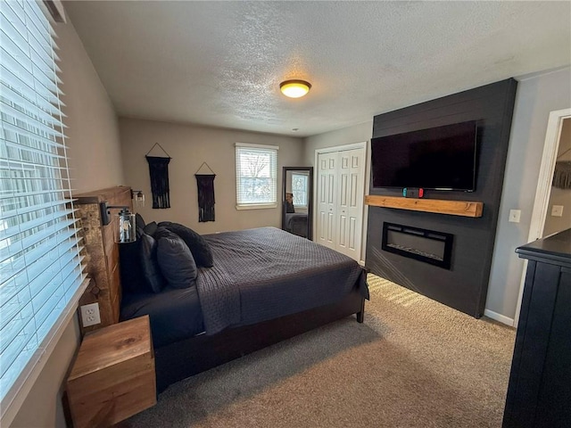 bedroom featuring carpet floors, a textured ceiling, and a closet