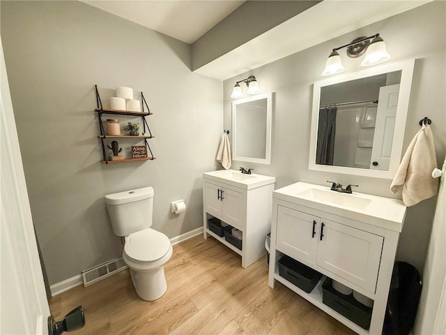 bathroom featuring vanity, toilet, wood-type flooring, and walk in shower