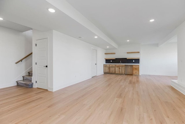 unfurnished living room with built in desk and light wood-type flooring