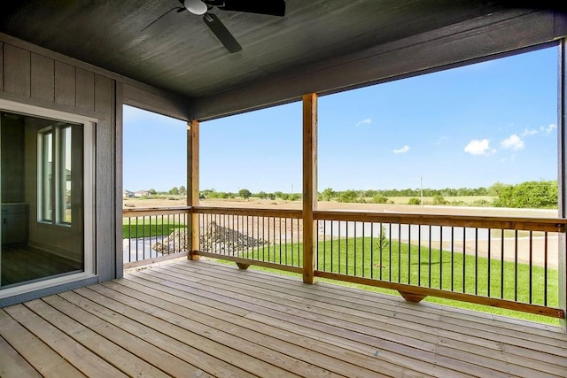 wooden terrace with a lawn and ceiling fan