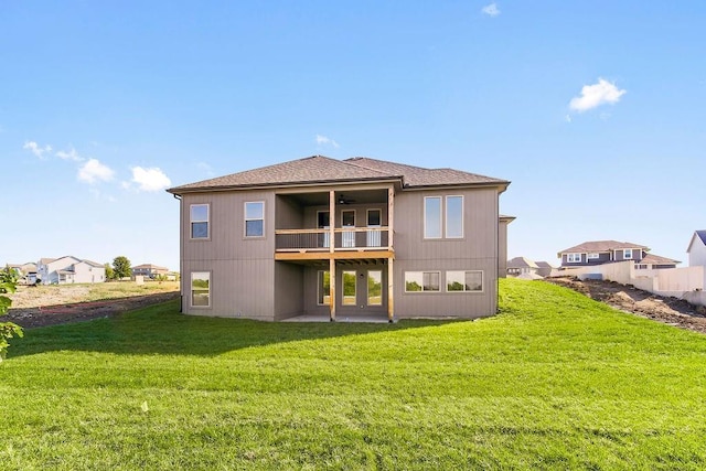 back of property with a lawn, a patio area, and a balcony