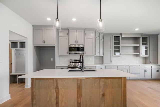 220 SW Chelmsford Dr, Blue Springs, MO 64015 - kitchen with light countertops, gray cabinets, a sink, light wood-style floors, and appliances with stainless steel finishes