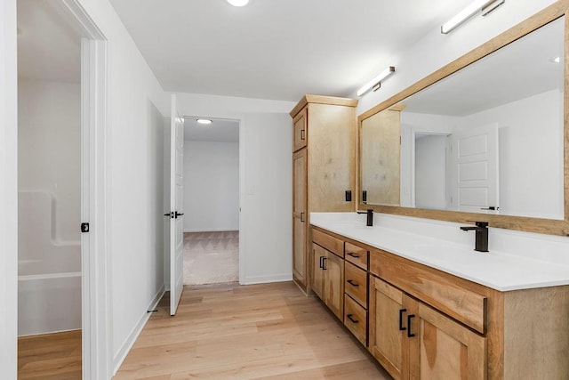 220 SW Chelmsford Dr, Blue Springs, MO 64015 - bathroom with baseboards, double vanity, a sink, and wood finished floors