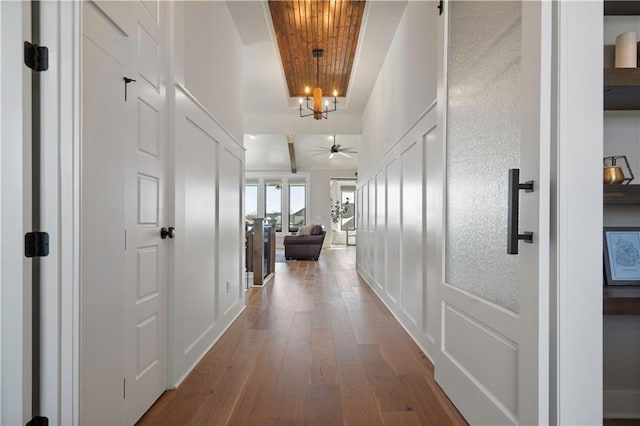 corridor featuring an inviting chandelier, wood ceiling, and wood-type flooring