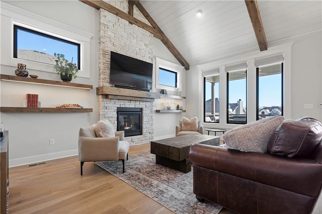 living room with a healthy amount of sunlight, a fireplace, and beam ceiling