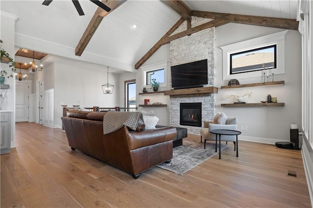 living room featuring ceiling fan, a fireplace, light hardwood / wood-style floors, vaulted ceiling with beams, and wooden ceiling