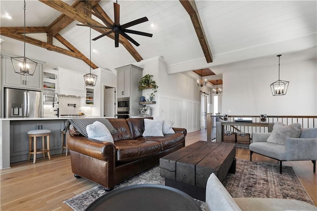 living room featuring ceiling fan, lofted ceiling with beams, and light hardwood / wood-style floors