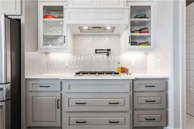 kitchen with custom exhaust hood, appliances with stainless steel finishes, decorative backsplash, and gray cabinets