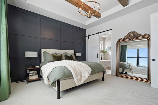 bedroom featuring carpet floors, ensuite bathroom, a barn door, and an inviting chandelier