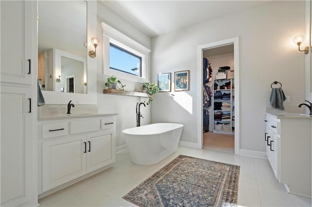 bathroom with tile patterned floors, vanity, and a bath