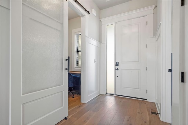 foyer with light hardwood / wood-style floors and a barn door