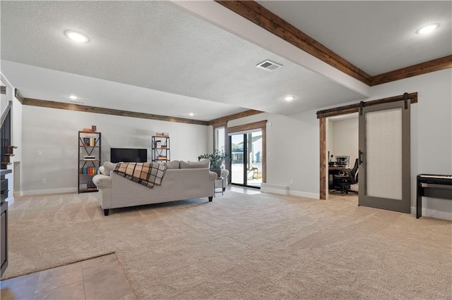 carpeted living room featuring beam ceiling, french doors, and a barn door