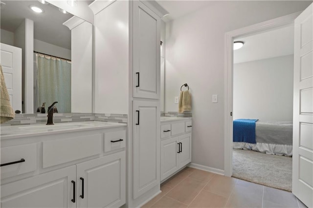 bathroom with vanity, decorative backsplash, and tile patterned floors