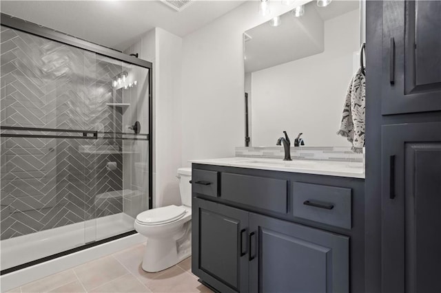 bathroom with toilet, vanity, tile patterned flooring, and a shower with door