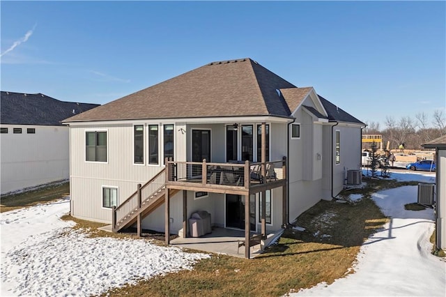 snow covered rear of property featuring cooling unit and a patio